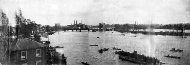 Photograph of the University Boat Race in 1886, with Hammersmith Bridge under construction. (click on the image to enlarge) Image via Wikimedia Commons.